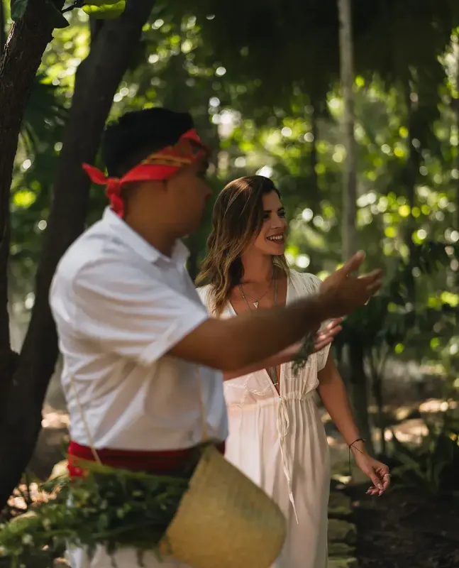 A guide shares a holistic Mayan experience with a guest in Mahekal Beach Resort's gardens