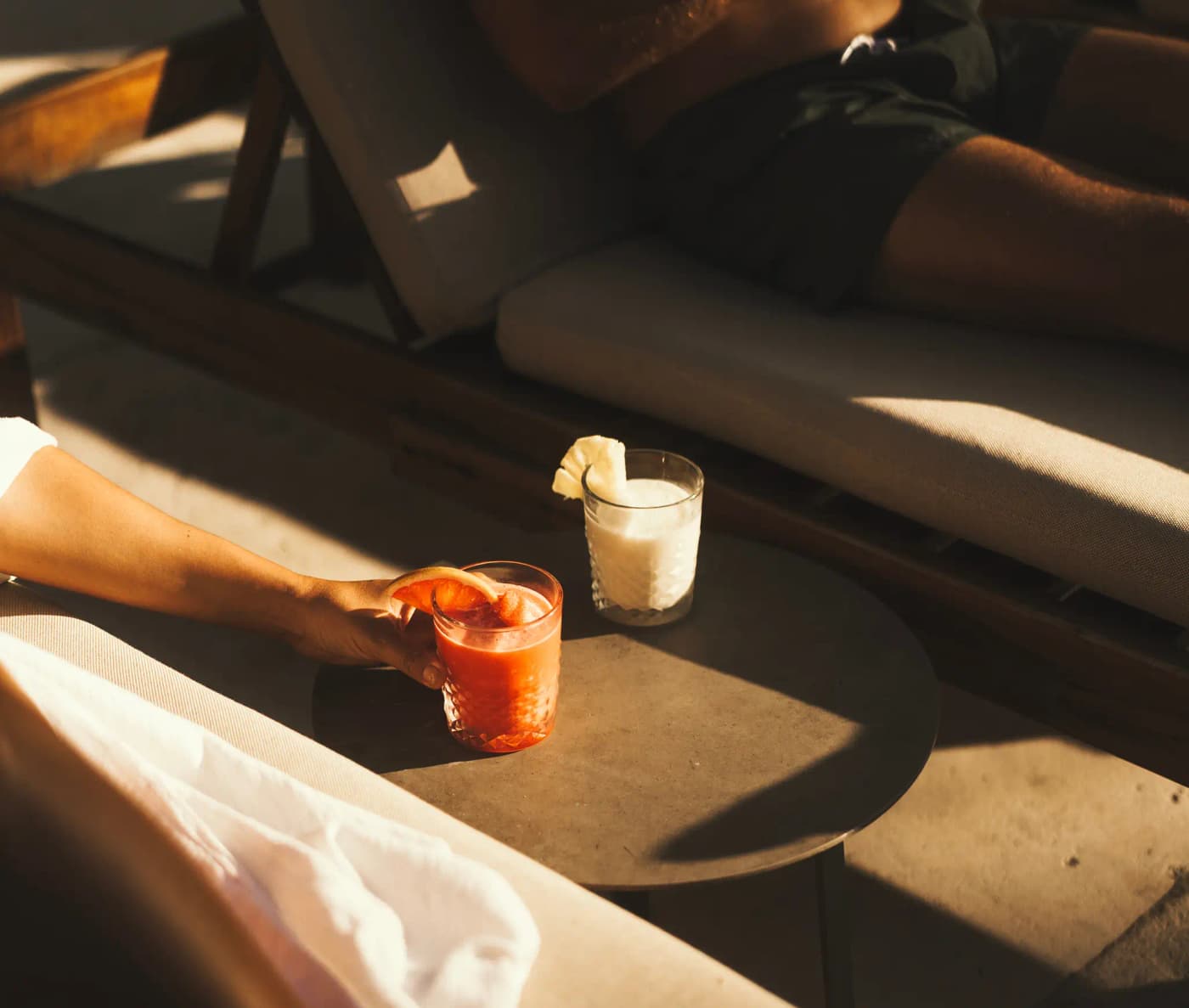 Person enjoying a tropical cocktail in a lounge area at Mahekal Beach Resort
